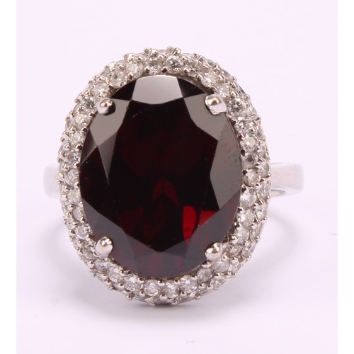 1169 - 18ct white gold Almandine/Pyrope Garnet and Diamond ring
The ring is set with an oval brilliant cut ... 