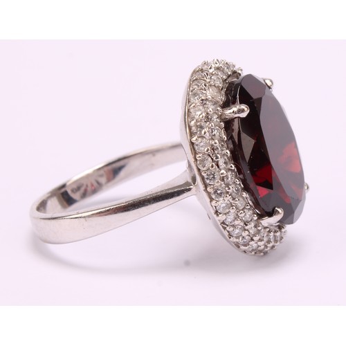 1169 - 18ct white gold Almandine/Pyrope Garnet and Diamond ring
The ring is set with an oval brilliant cut ... 