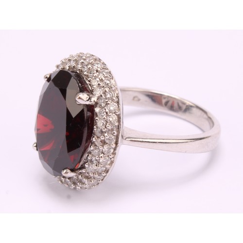 1169 - 18ct white gold Almandine/Pyrope Garnet and Diamond ring
The ring is set with an oval brilliant cut ... 