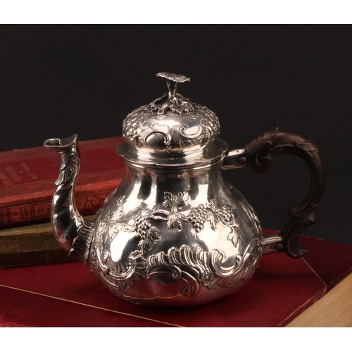 982 - An 18th century German silver pear shaped teapot, chased with fruiting vine and flowering C-scrolls,... 