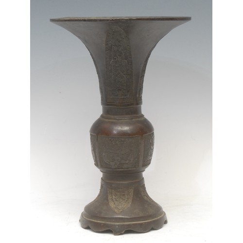 1284 - A Chinese patinated bronze gu vase, cast in the Archaic taste, 27cm high, Yuan Dynasty character mar... 