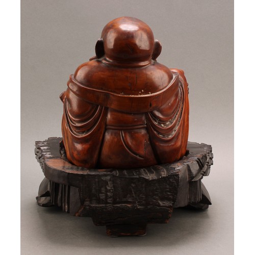 1286 - A 19th century Chinese carved hardwood figure of Putai or Buddha, seated scantily draped in robes ho... 