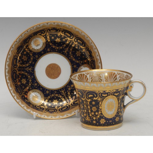 46 - A Chamberlains Worcester coffee cup and saucer, decorated with circular and oval gilt bosses, on a c... 