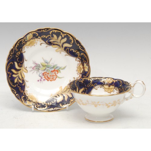 46 - A Chamberlains Worcester coffee cup and saucer, decorated with circular and oval gilt bosses, on a c... 