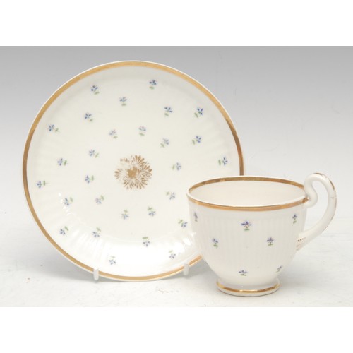 111 - A Swansea reeded teacup and saucer, decorated with scattered cornflowers, gilt rims, gilt bell husks... 