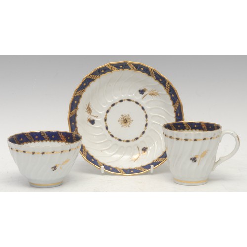 73 - A Flight Worcester spirally fluted trio, with blue and gilt border, early 19th century; a similar Ch... 