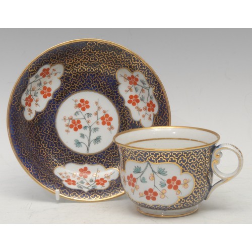 54 - A Chamberlains Worcester teacup and saucer, painted in the Kakiemon style, with flowers within shape... 