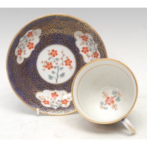 54 - A Chamberlains Worcester teacup and saucer, painted in the Kakiemon style, with flowers within shape... 