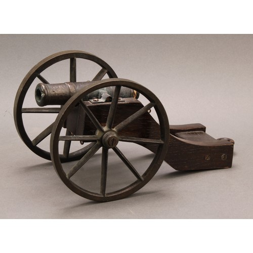 2218 - A bronze library model signalling cannon, 13cm barrel, the oak carriage with bronze wheels, 28cm lon... 