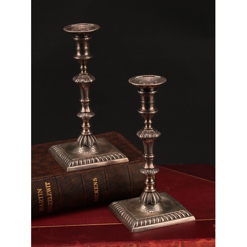 857 - A pair of early George III cast silver taper sticks, knoppeds pillars, square bases with gadrooned b... 