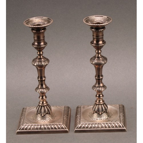 857 - A pair of early George III cast silver taper sticks, knoppeds pillars, square bases with gadrooned b... 