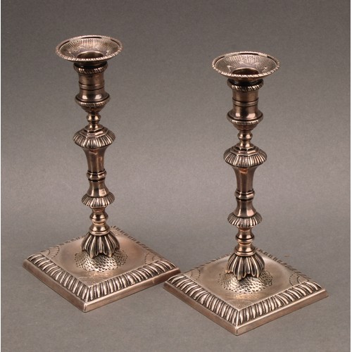 857 - A pair of early George III cast silver taper sticks, knoppeds pillars, square bases with gadrooned b... 