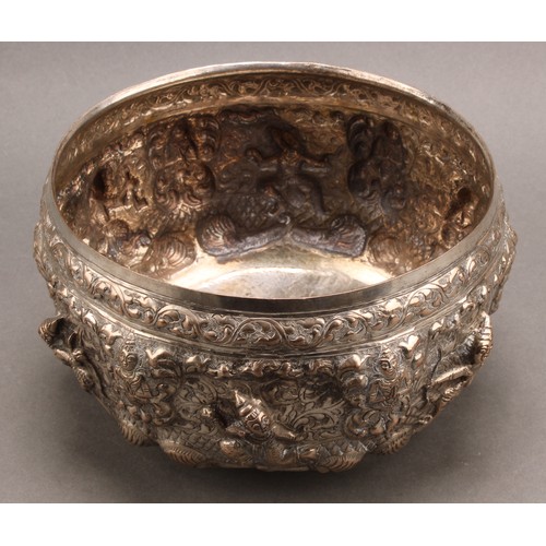 719 - A Burmese silver bowl, repousse chased with deities and figures on a ground of leafy scrolls, 17cm d... 