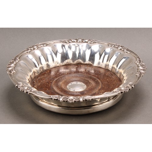 1021 - An Edwadian silver fluted circular magnum size wine coaster, of Regency design, draught-turned base,... 