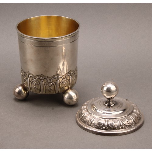 981 - An 18th century German silver cup and cover, chased with bands of leaves and ovolo strapwork, ball f... 