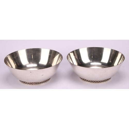 1103 - Georg Jensen - a pair of Danish silver circular bowls, designed by Sigvard Bernadotte, cast feet wit... 