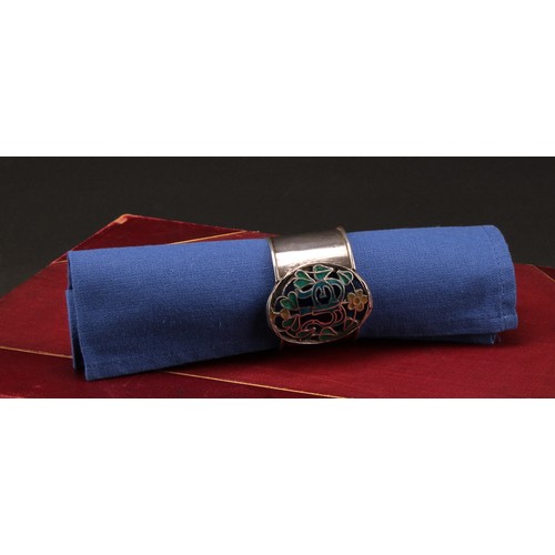 999 - An Arts and Crafts silver and enamel napkin ring, pierced and decorated in polychrome with flowers a... 