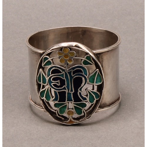 999 - An Arts and Crafts silver and enamel napkin ring, pierced and decorated in polychrome with flowers a... 