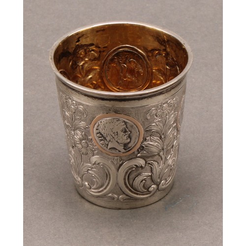 736 - A Continental silver tapered cylindrical beaker, chased with flowering leafy stems and set with Roma... 