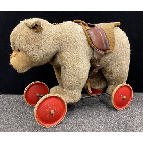 6527 - A mid 20th century Ride on Bear, possibly steiff, glass eyes, shaped snout, wood wool stuffing, meta... 