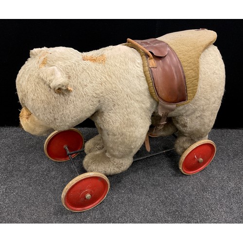 6527 - A mid 20th century Ride on Bear, possibly steiff, glass eyes, shaped snout, wood wool stuffing, meta... 