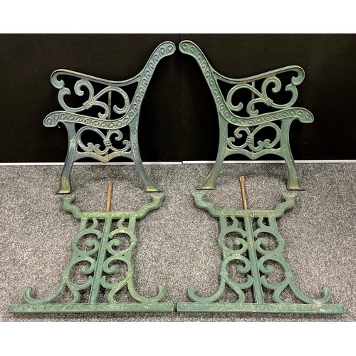 601A - A pair of cast iron bench ends, similar table legs, all painted green. The bench ends 76.5cm high, t... 