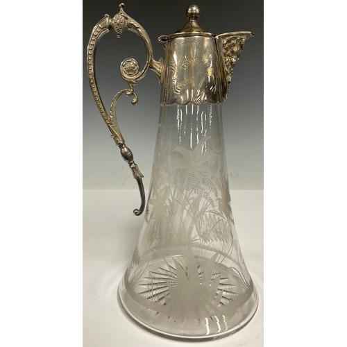 67 - An 'Edwardian' claret jug, domed cover, scroll handle, cast spout, above clear glass engraved and et... 