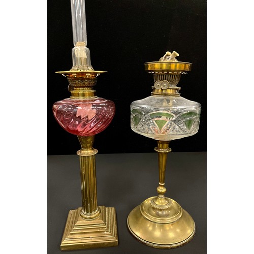 60 - A cranberry swirl glass oil lamp, 66cm high, a painted cut glass oil lamp with circular base, 44cm h... 