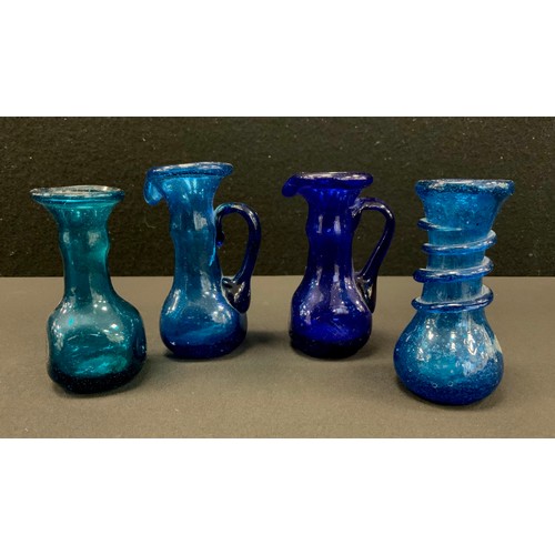 50 - A group of four Roman style glass unguentaria 9cm high, (4).