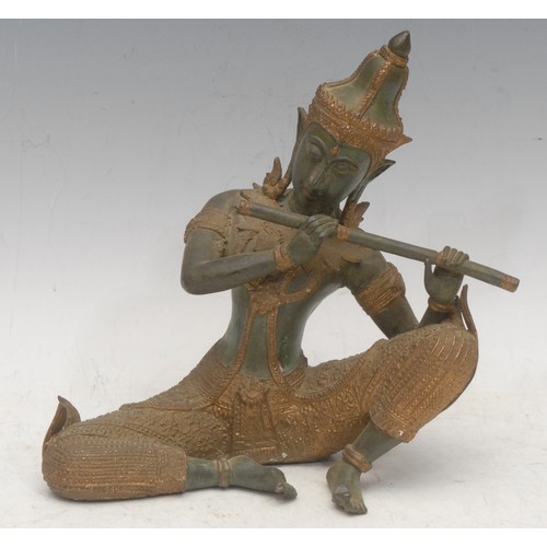 3561 - A Thai Buddhist patinated bronze, cast as a Gandharva (celestial musician) playing a flute, picked o... 