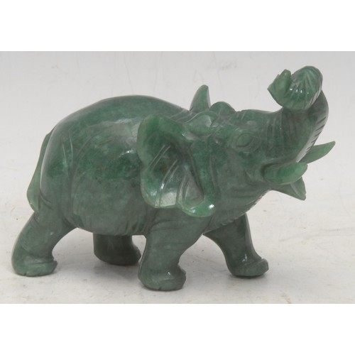 3629 - A carved composite jade elephant, trunk raised, 8.5cm high, 11cm long