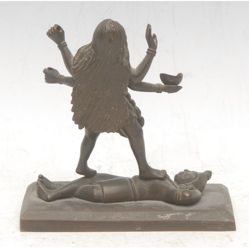 3571 - An Indian Hindu bronze figure group, Kali and Shiva, in typical pose with the goddess standing upon ... 