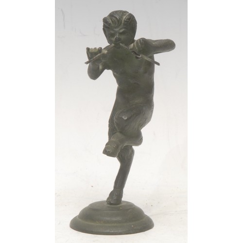 3558 - A patinated bronze, of a Pan, he stands with one leg raised, playing pipes, circular base, 12cm high