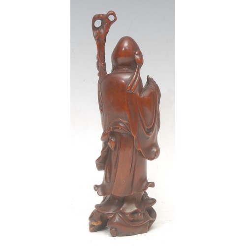 3053 - A Chinese boxwood figure, carved as Shou Lao, he stands, holding a scroll, 20cm high, 19th/early 20t... 