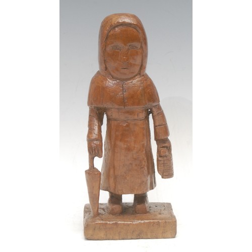 3619 - Folk Art & Treen - a 19th century softwood carving, of an old maid carrying an umbrella and bread ba... 