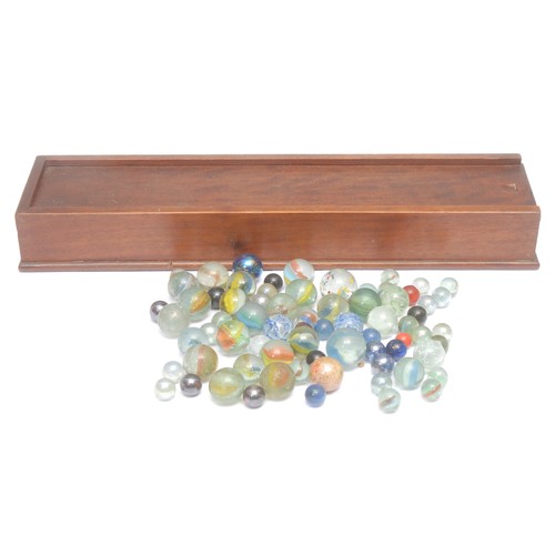 3063 - A collection of 19th century and later marbles, the mahogany box with sliding cover, 42.5cm wide