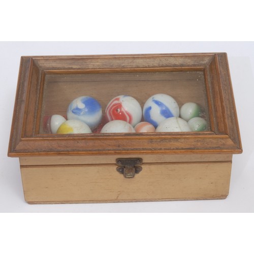 3064 - A collection of 19th century marbles, within a bjouterie box with glazed cover, 14cm wide