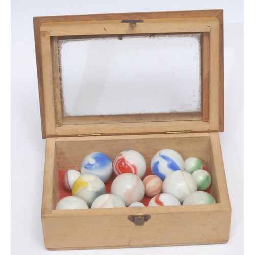 3064 - A collection of 19th century marbles, within a bjouterie box with glazed cover, 14cm wide