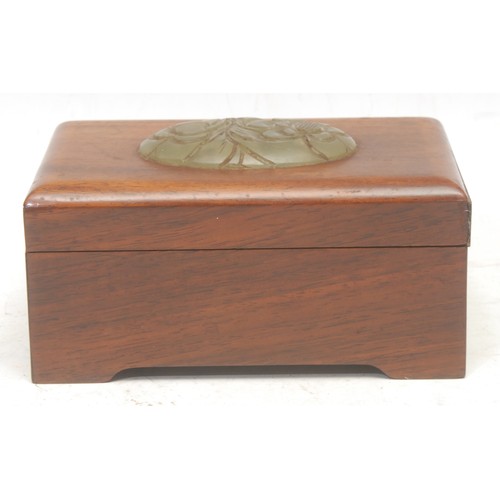 3058 - A Chinese hardwood box, the cover mounted with an oval jade panel carved with chrysanthemums, 13cm w... 