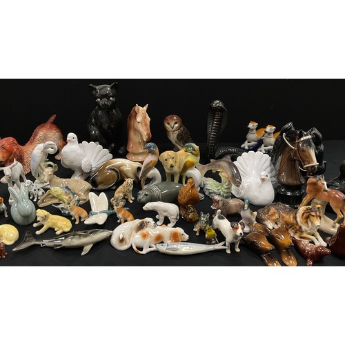 67 - A collection of model ceramic animals including; a pair of Staffordshire style greyhounds, cats, dog... 