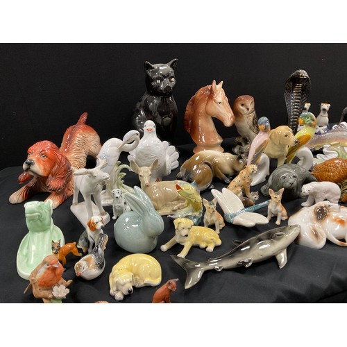 67 - A collection of model ceramic animals including; a pair of Staffordshire style greyhounds, cats, dog... 