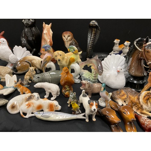 67 - A collection of model ceramic animals including; a pair of Staffordshire style greyhounds, cats, dog... 