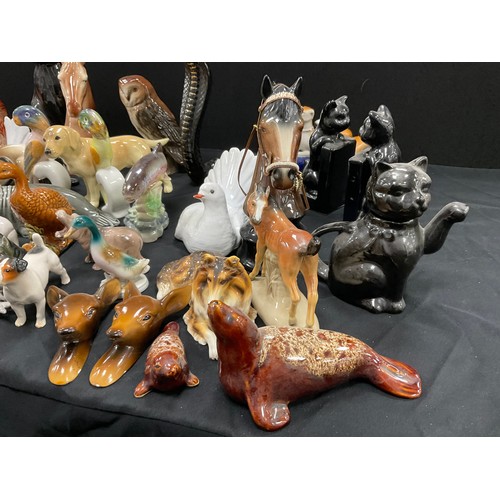 67 - A collection of model ceramic animals including; a pair of Staffordshire style greyhounds, cats, dog... 