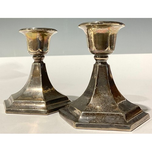 57 - A pair of George V silver boudoir candlesticks, spreading hexagonal base, 9cm high, Chester 1920