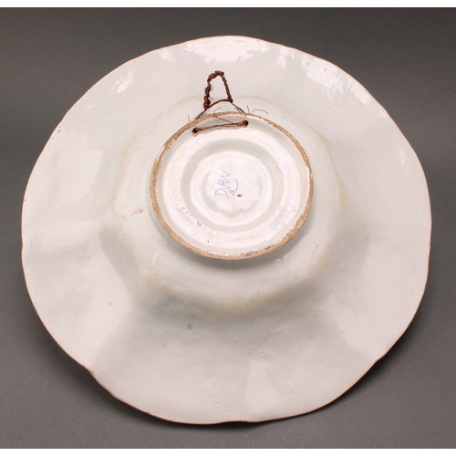 159 - A Delft lobed circular dish, painted in polychrome, with a peacock in a garden setting, the rim with... 