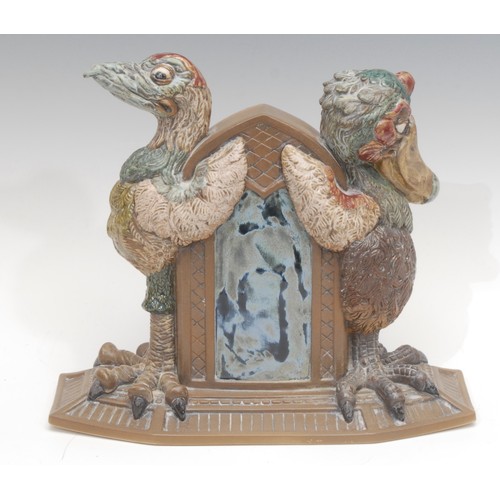 4050 - A Burslem Pottery stoneware mantel clock, the circular dial flanked by a pair of a grotesque 'Wally'... 