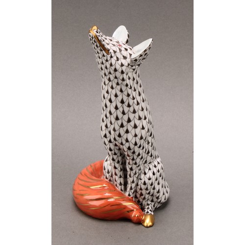 4068 - A Herend porcelain model, of a seated fox, painted in black fishnet pattern, orange tail, picked out... 