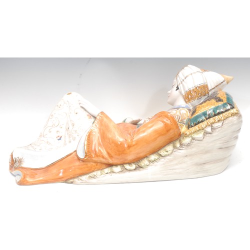 4072 - A large Italian faience figure, after D. Polo Uiato, of a reclining boy, wearing traditional Morocca... 