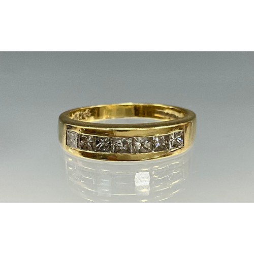 6240 - An 18ct gold princess cut diamond eternity ring set with seven princess cut diamonds, total diamond ... 