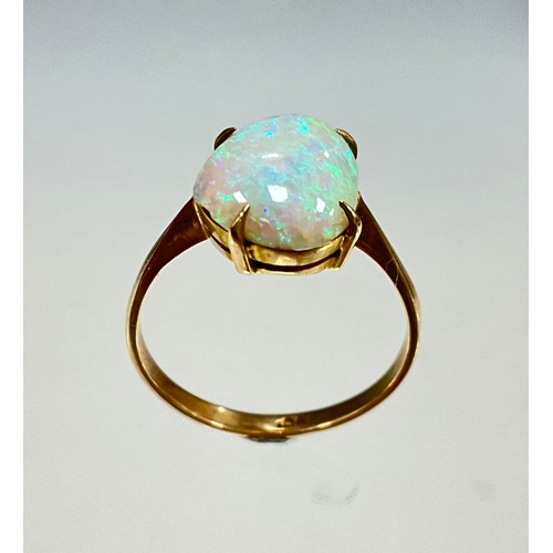 6276 - An opal cabochon ring, free form opal with vibrant blue green and red colour play, 9ct gold shank, s... 